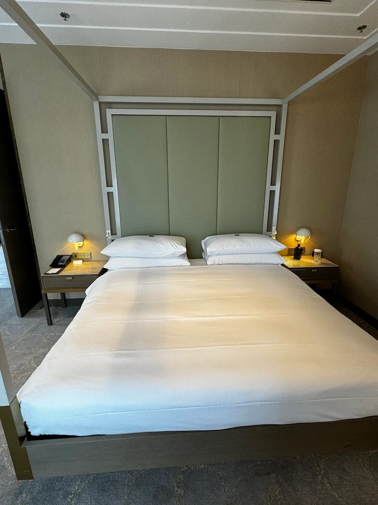 Hotelzimmer mit Doppelbett und grauem Hintergrund