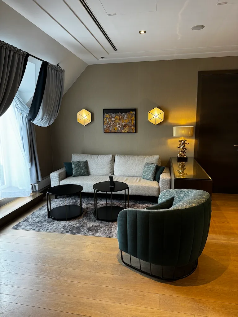 Modernes Hotelzimmer mit Couch und Sessel in Grautönen