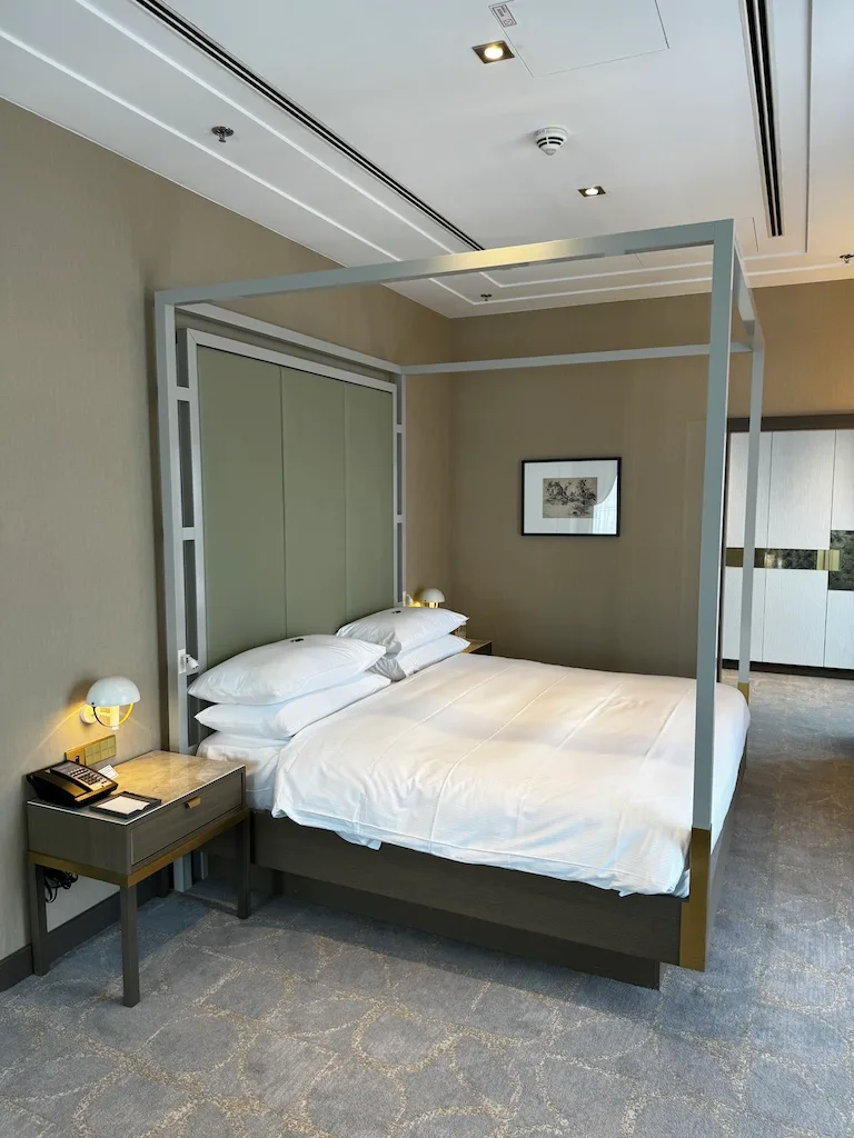 Hotelzimmer mit Doppelbett und grauem Vorhang