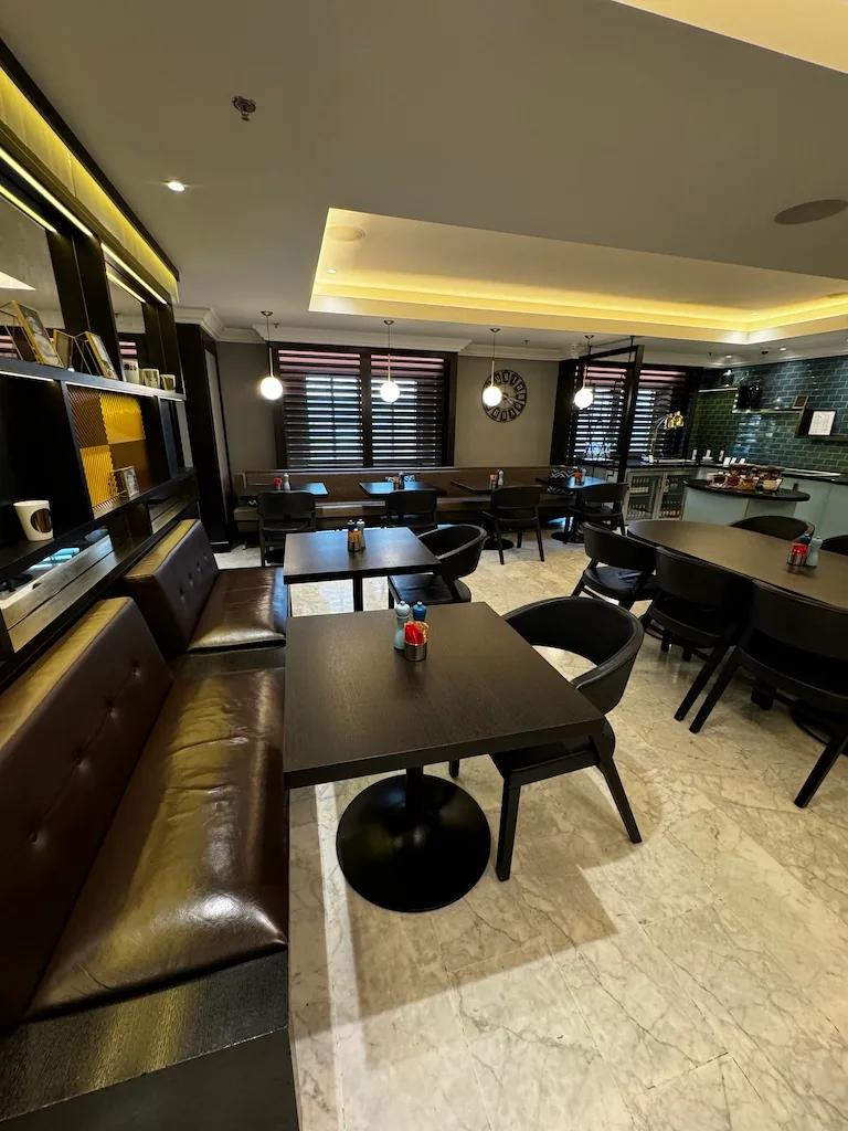 Hotelrestaurant mit Holztischen und schwarzen Stühlen