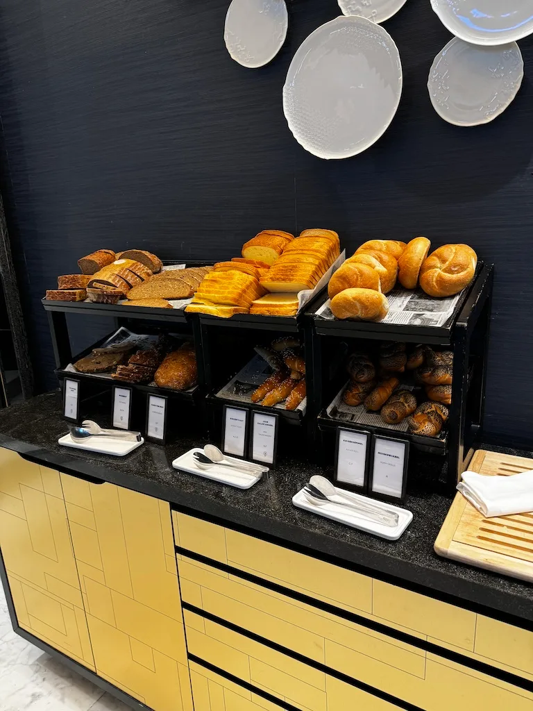 Frühstückstheke mit verschiedenen Brotarten und Butter auf schwarzem Regal