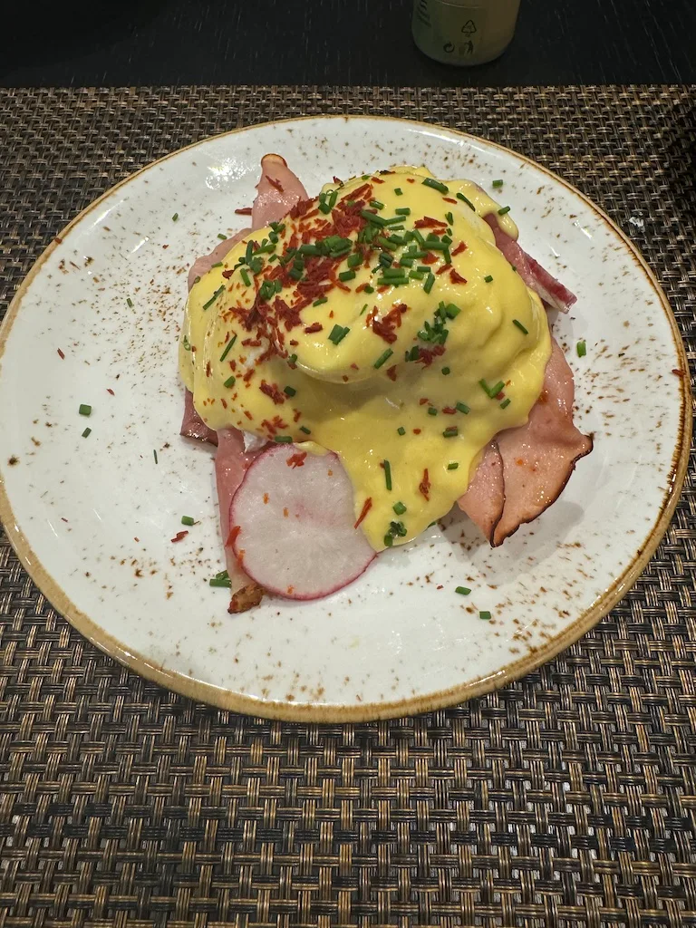 Eierbrötchen mit Speck und Ei-Sahne-Sauce auf Teller