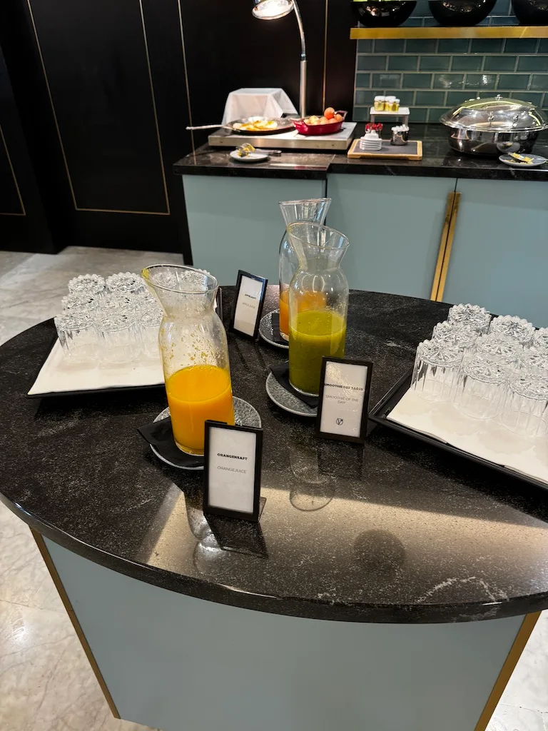 Frühstückstablett mit Orangensaft und Saftkaraffen auf Marmorplatte