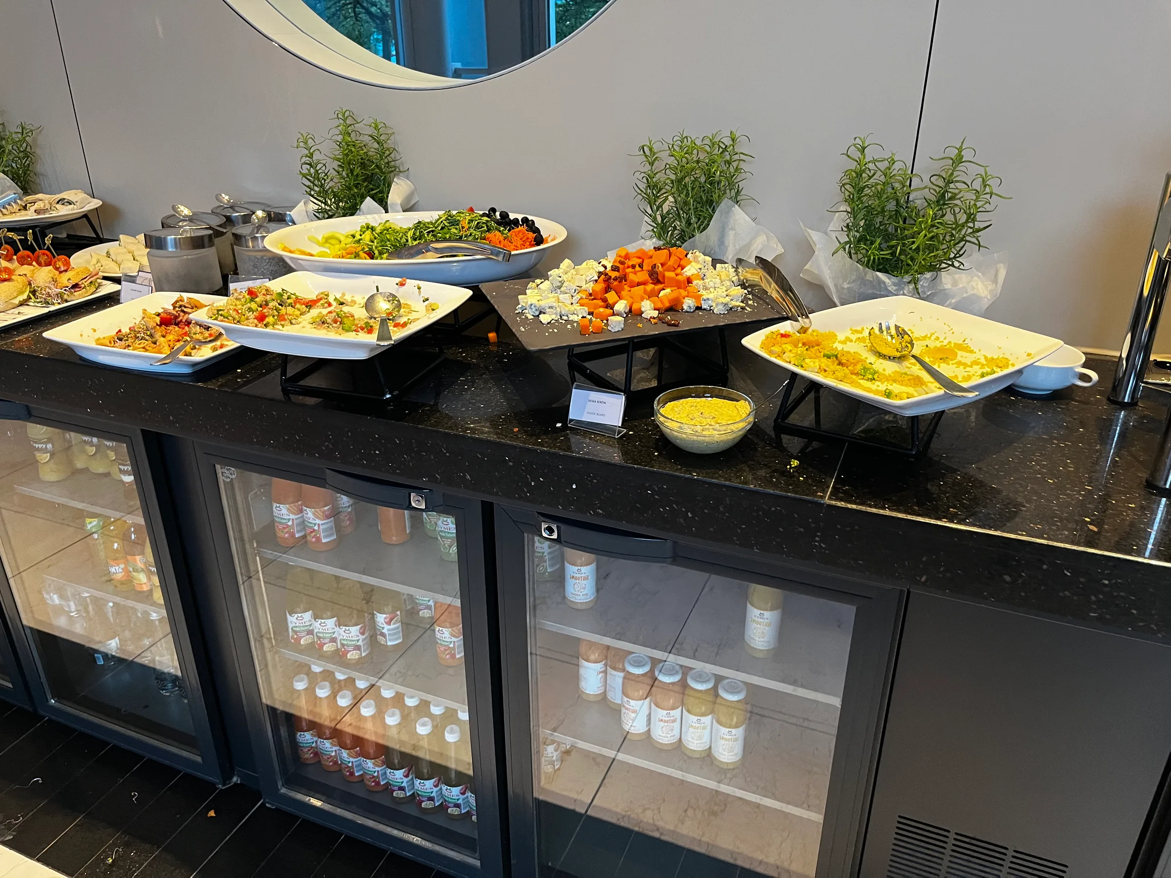Buffet mit verschiedenen Gerichten und Salaten auf einem schwarzen Tisch