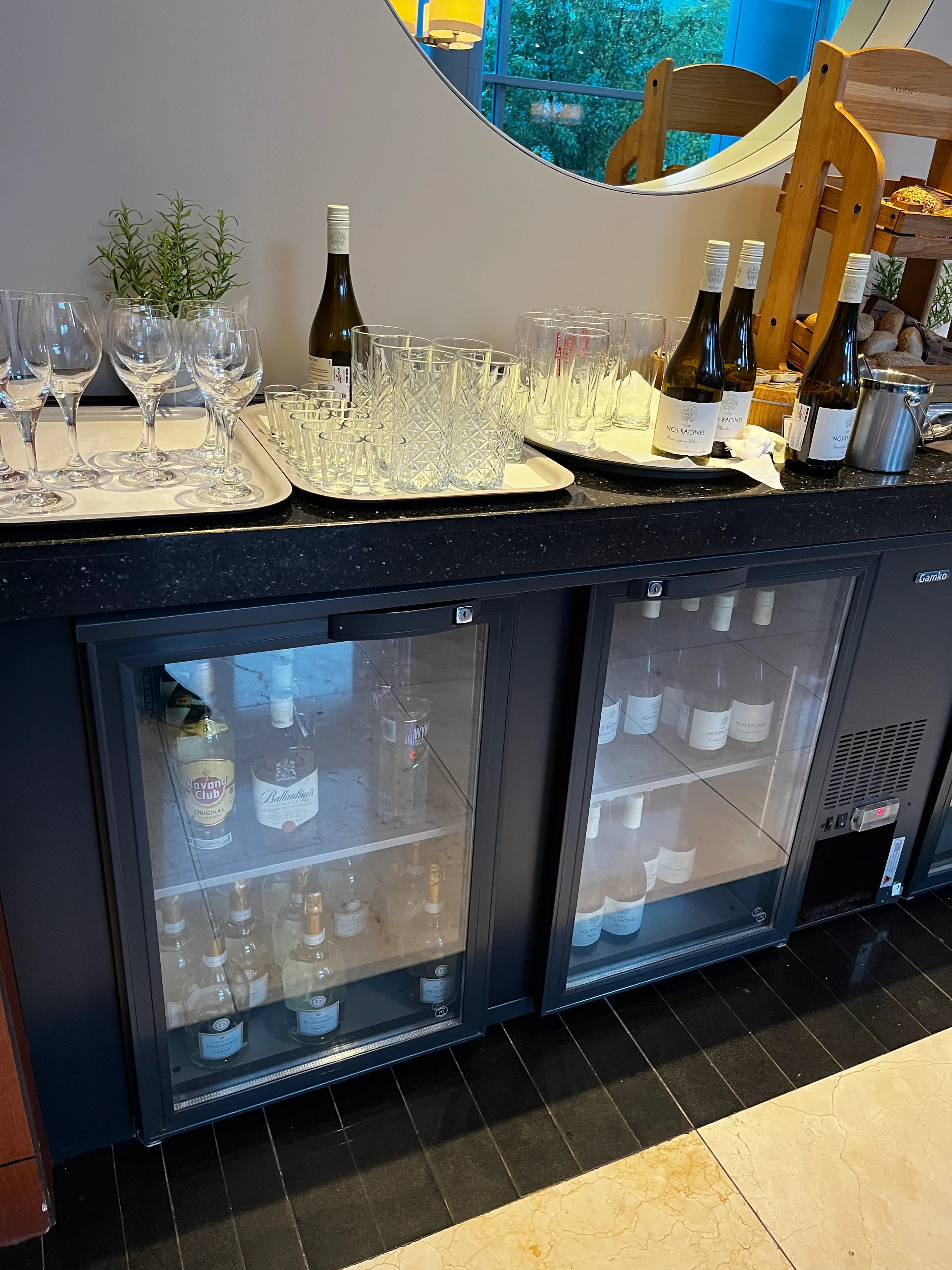 Hotelbar mit Weinflaschen und Gläsern auf Tischen