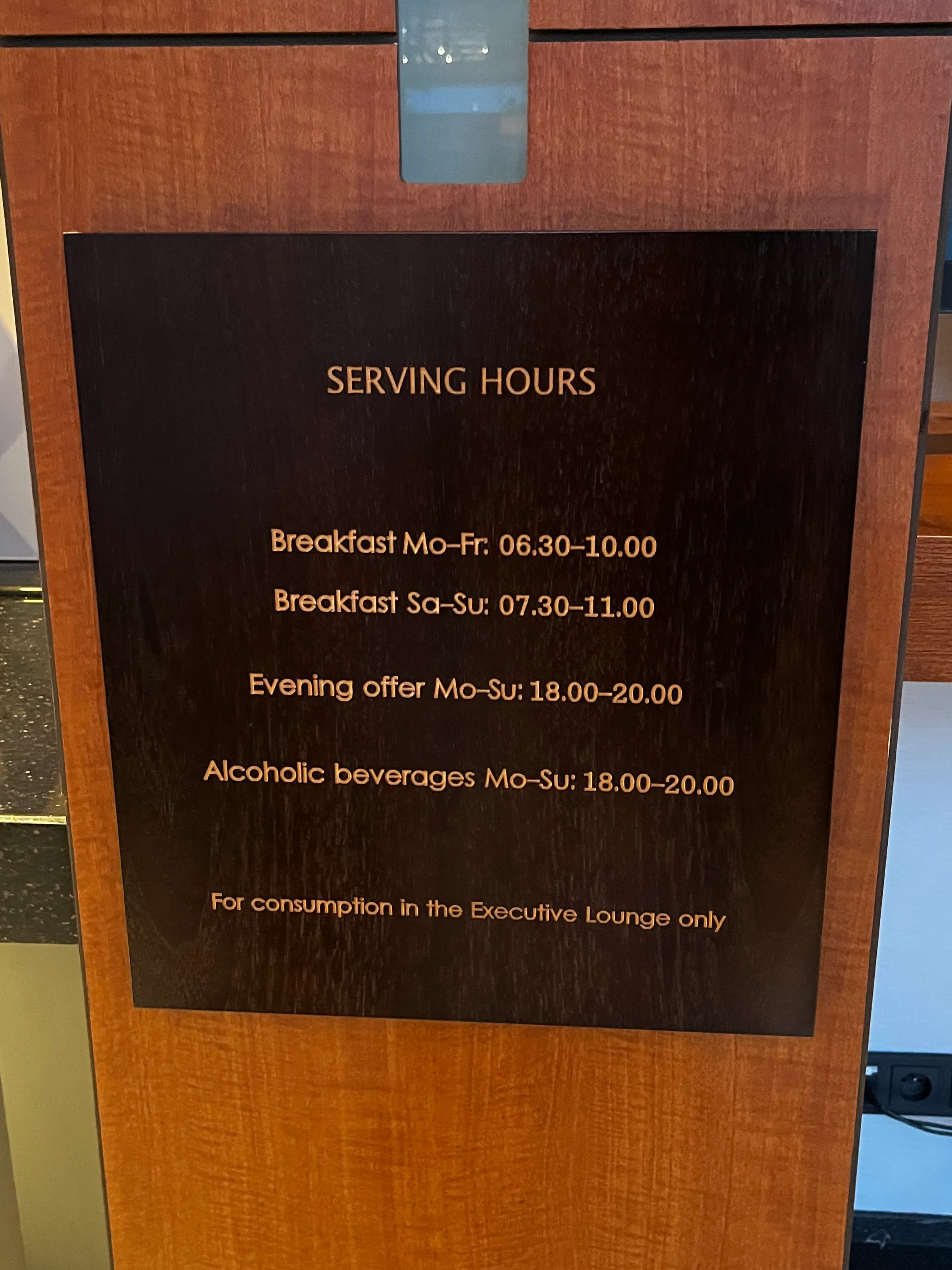 Schild mit Essenszeiten für Executive Lounge