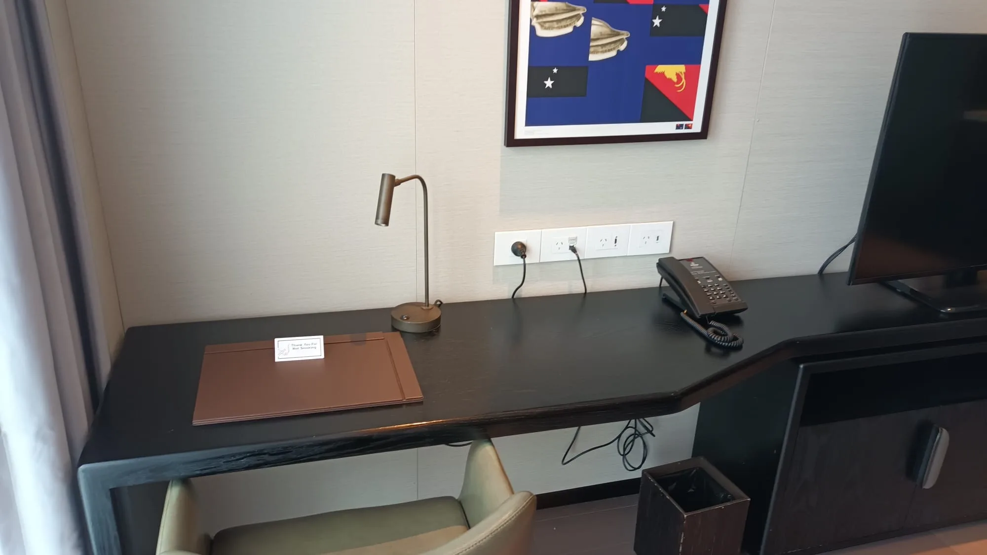 Hotelzimmer mit Schreibtisch, Telefon und Lampe