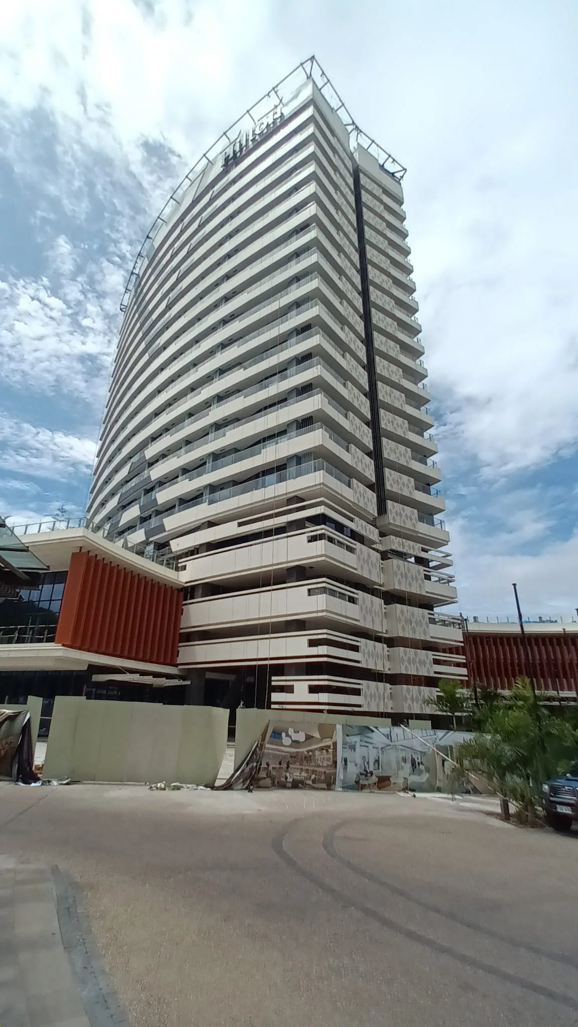 Hochhaus mit vielen Balkonen unter blauem Himmel