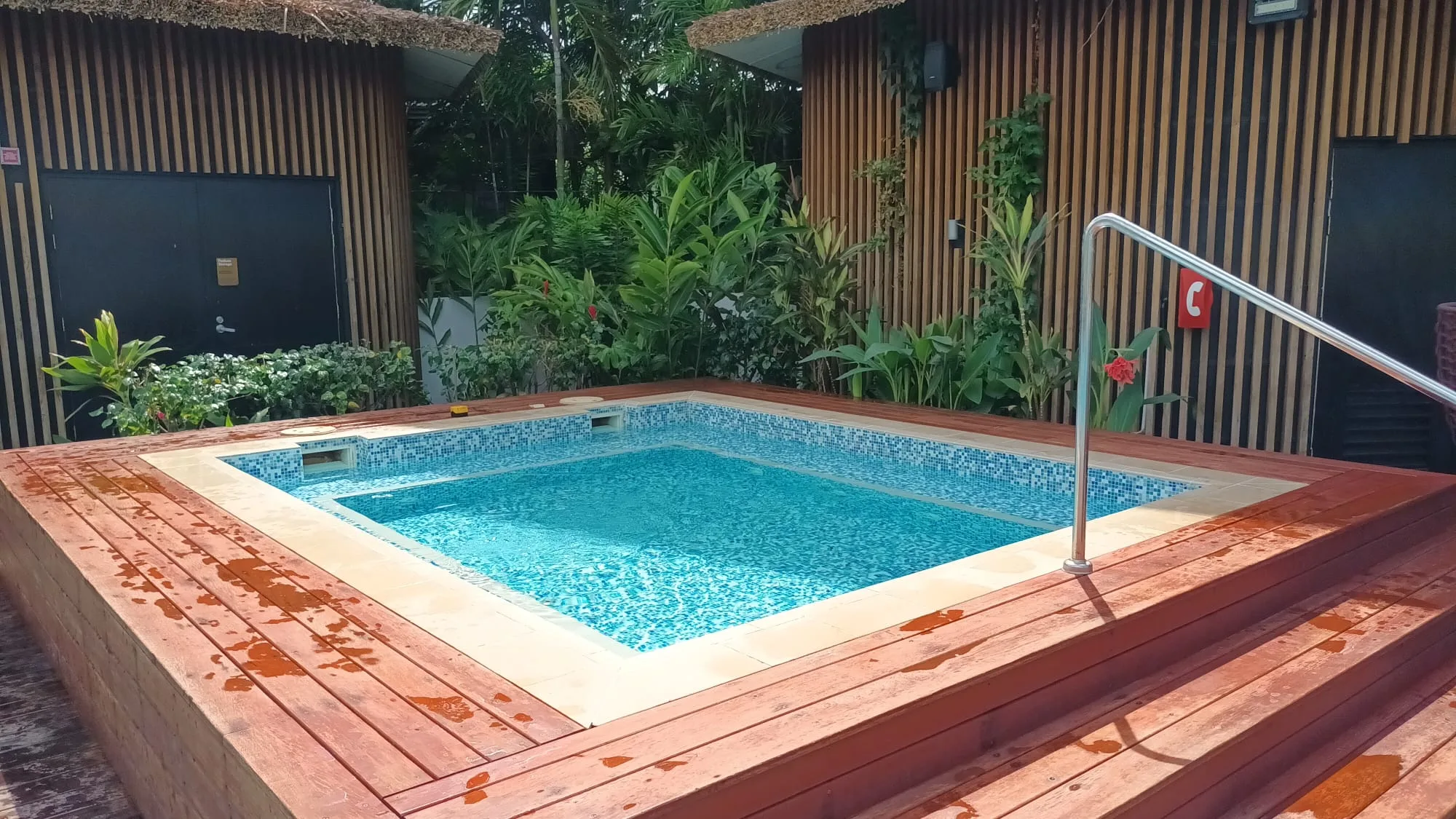 Becken mit Mosaikfliesen und Holzumrandung