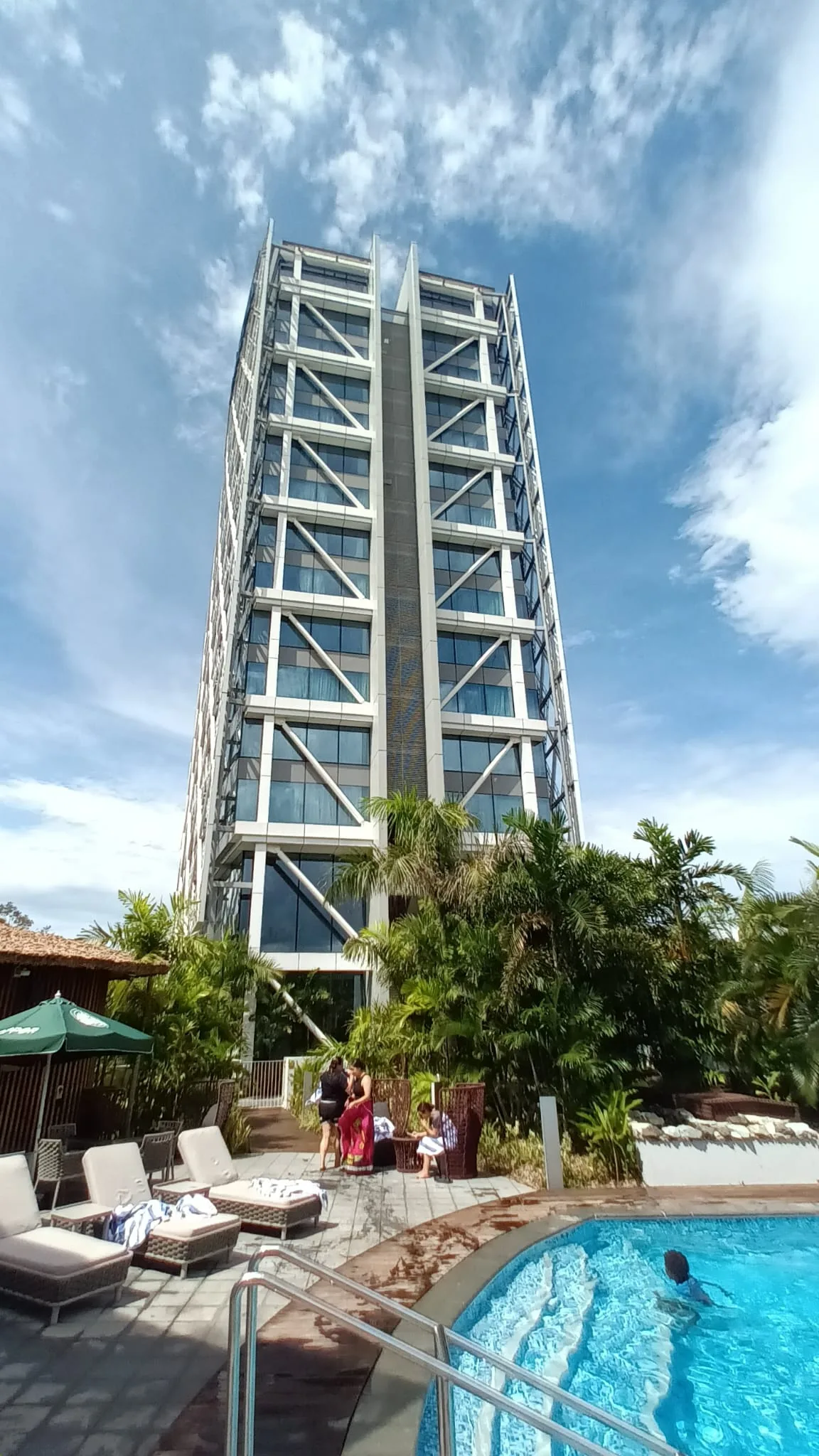 Hochhaus mit Pool und Palmen im Vordergrund
