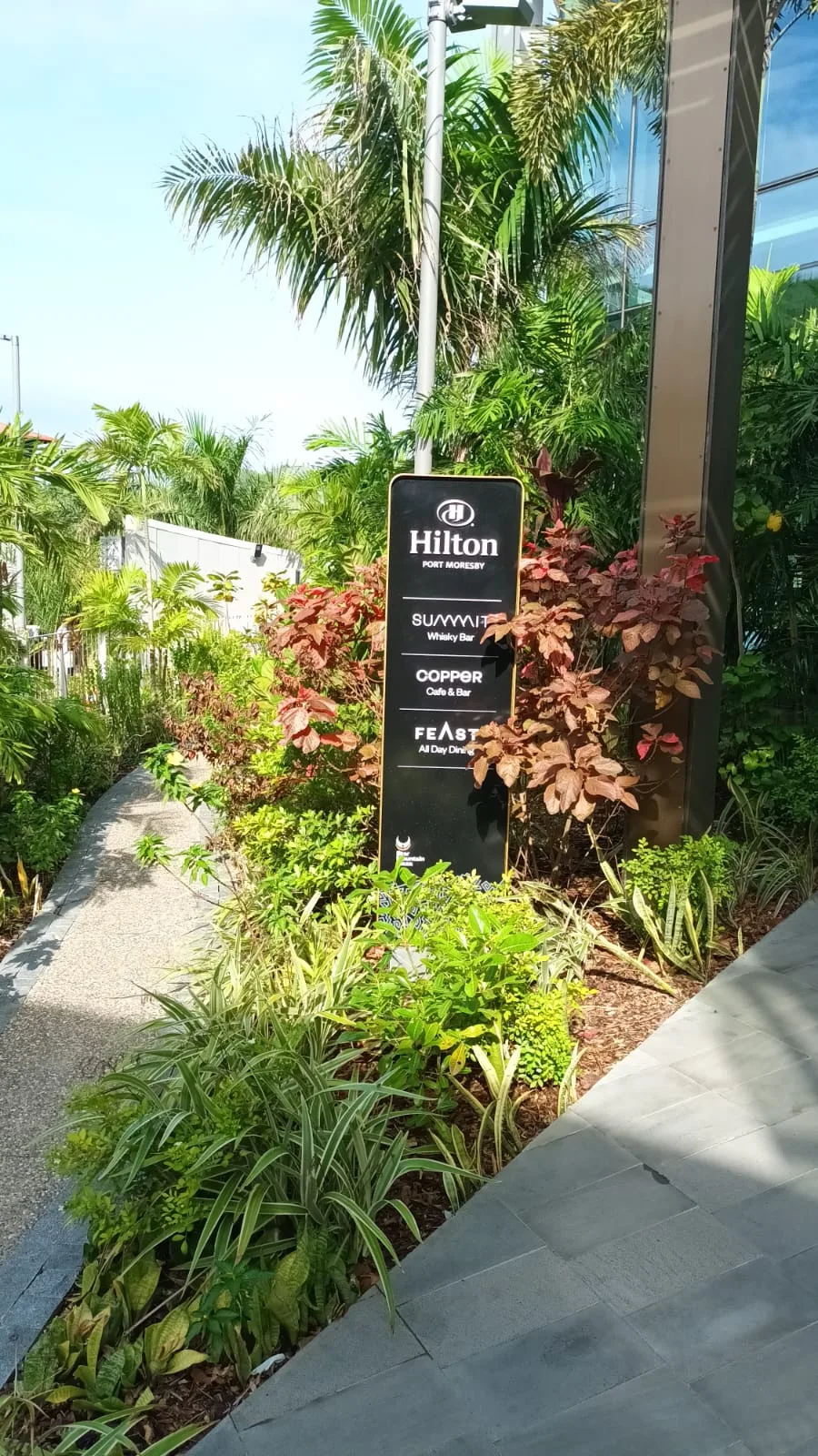 Hotel-Schild mit Namen und Restaurants am Wegrand