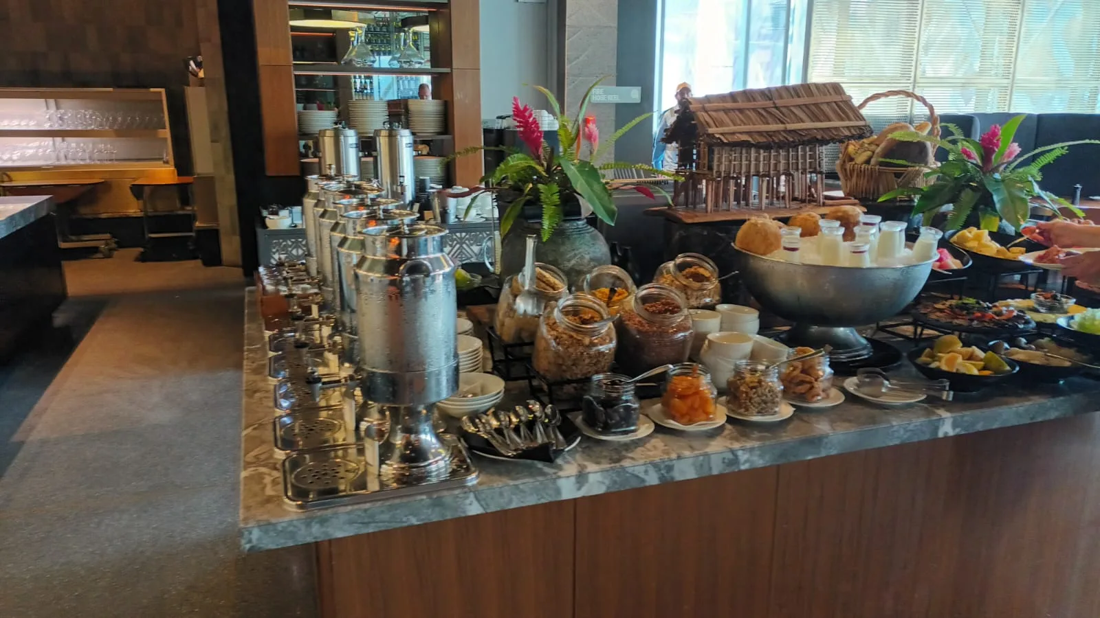 Frühstücksbuffet mit verschiedenen Getränken und Snacks auf einem Marmertisch