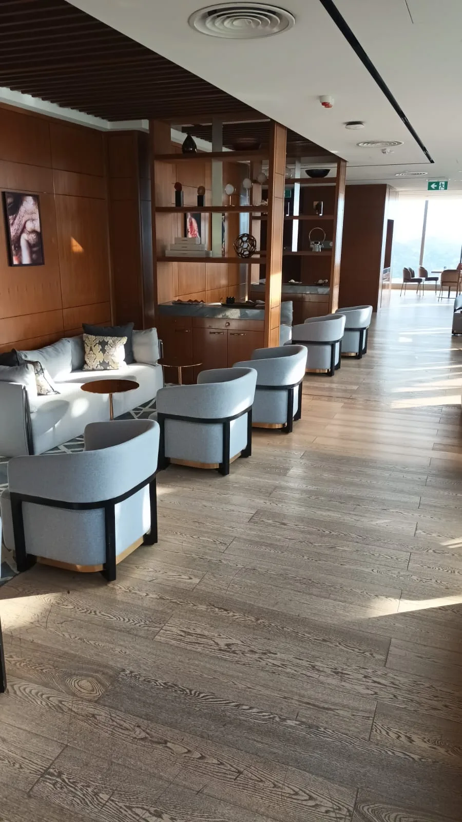 Lounge mit Sesseln und Holzregal im Hotel