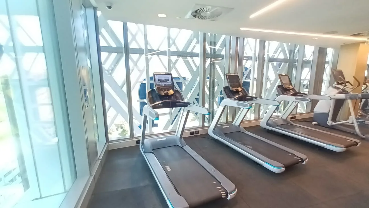 Gesunde Fitnessgeräte im Hotelgym mit großen Fenstern