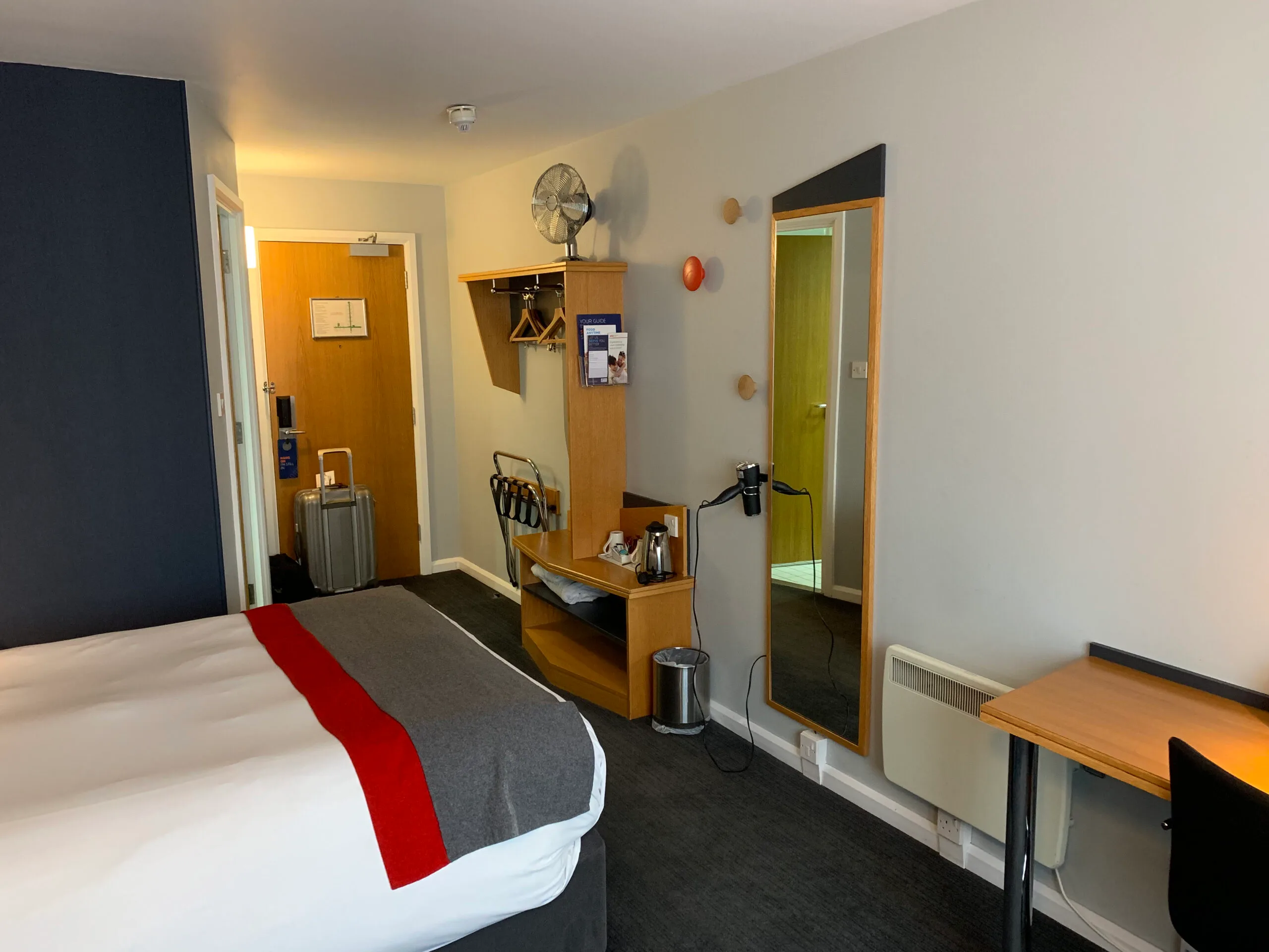Hotelzimmer mit Doppelbett und grauem Tagesdeckenbezug