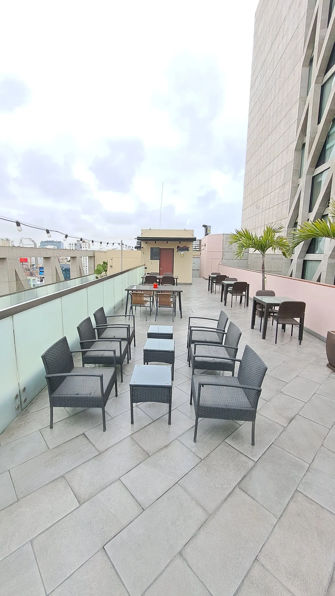 Terrasse mit Stühlen und Tischen auf einem Dach