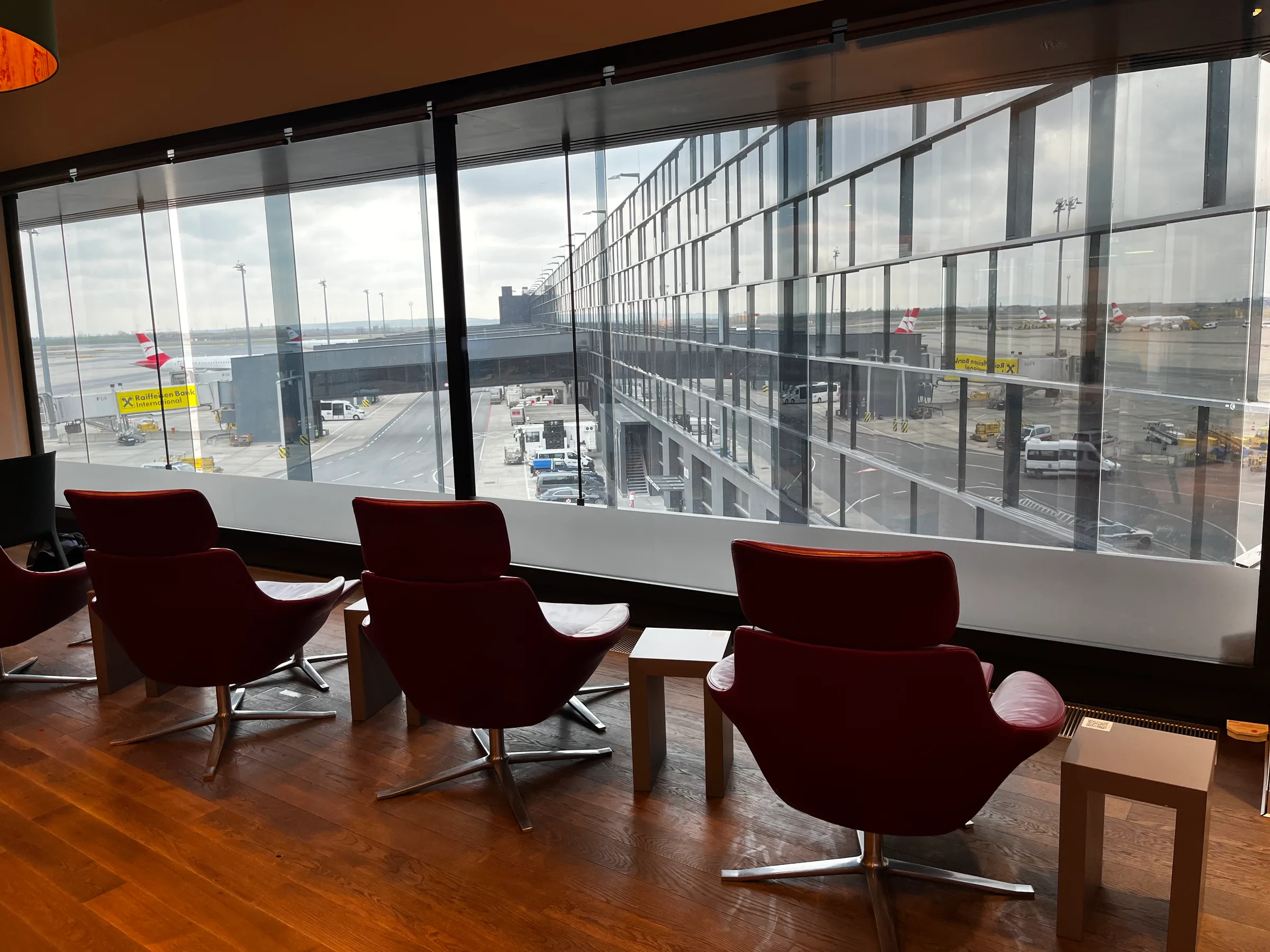 Rot-sessel im Flughafenlounge mit Blick auf Rollfeld und Flugzeuge