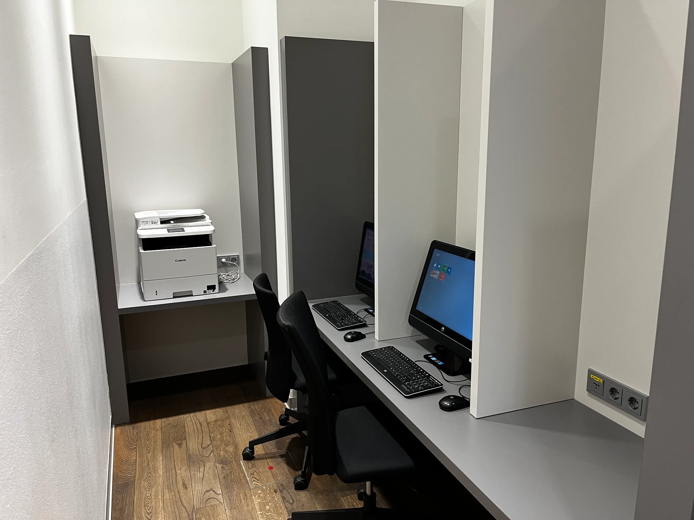 kleiner Arbeitsplatz mit Drucker und Computern
