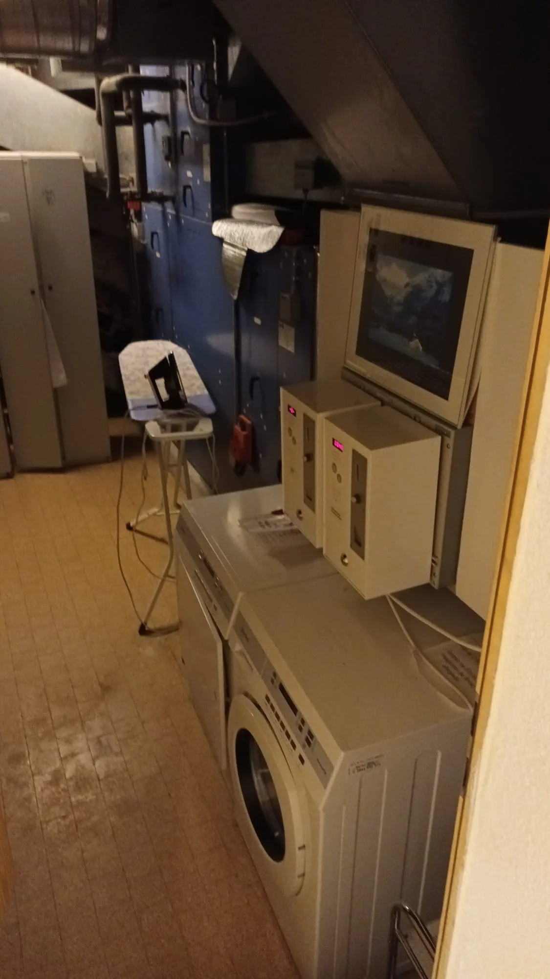 Waschmaschine und Trockner in Hotel mit Monitor und altem Computer