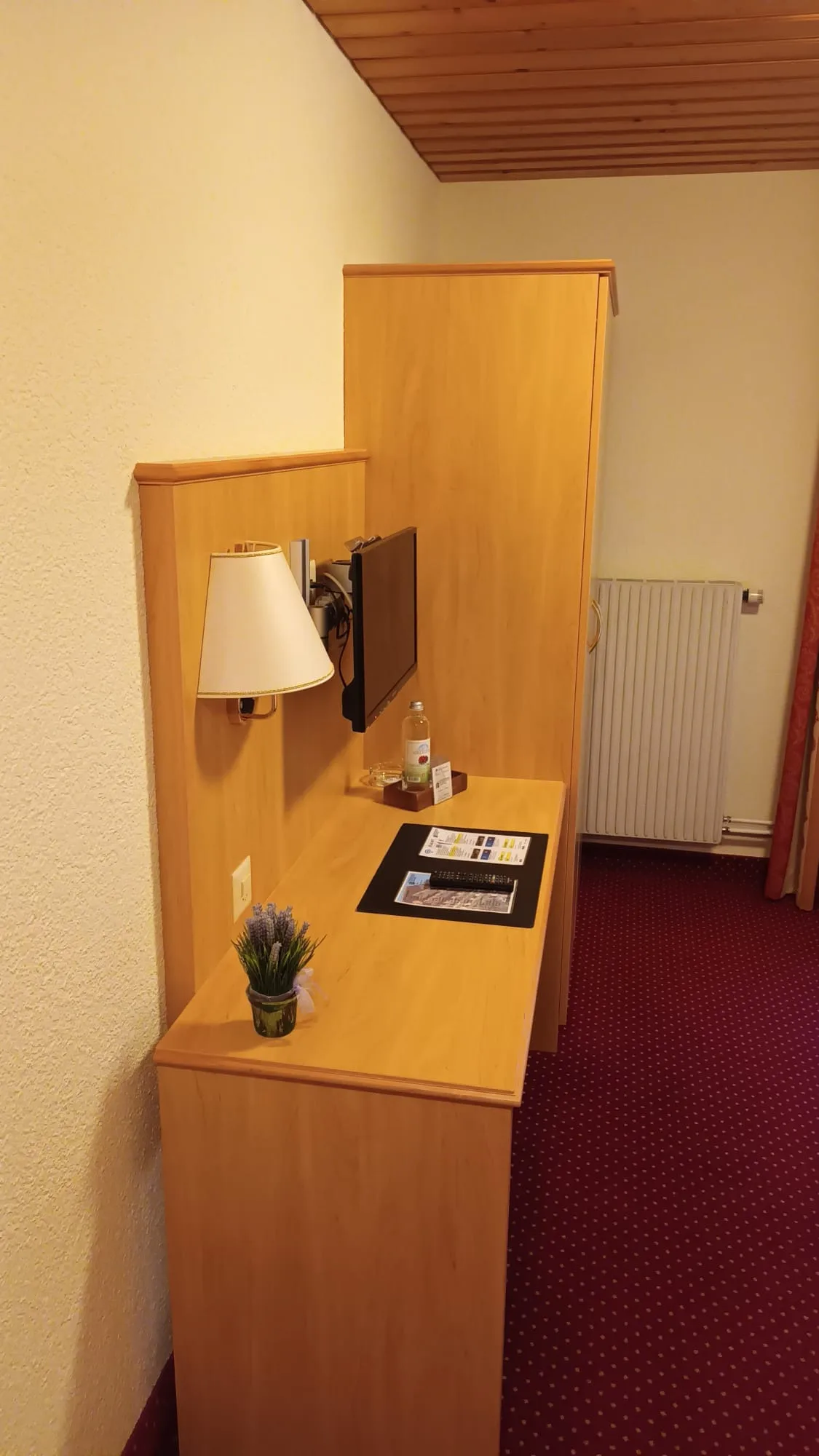 Hotelzimmer mit Schreibtisch, Lampe und Flachbildfernseher