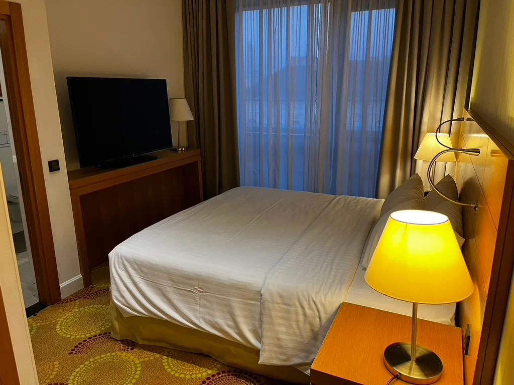 Hotelzimmer mit Doppelbett und Fernseher