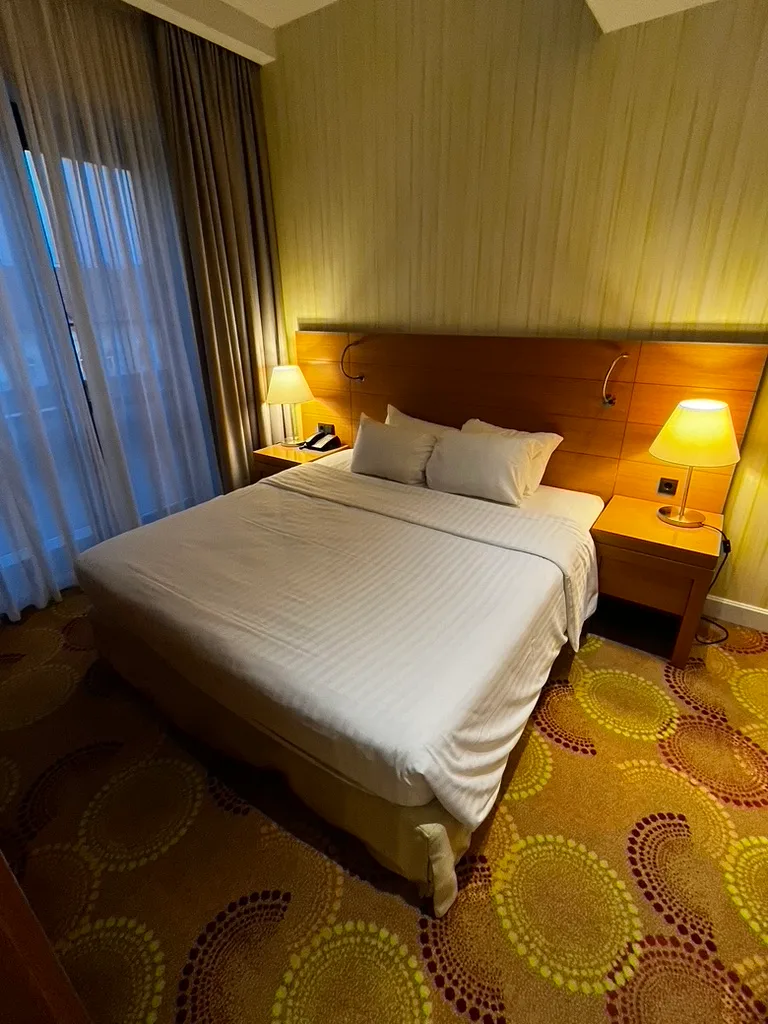 Hotelzimmer mit Doppelbett und Nachttischen