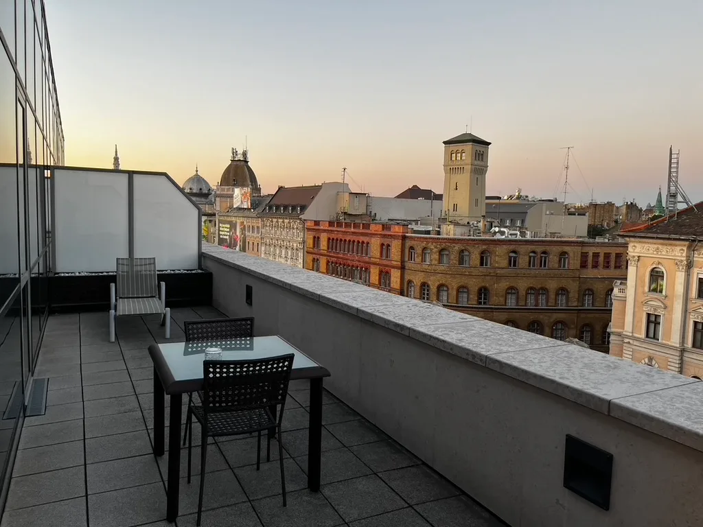 Terrasse mit Tisch und Stühlen auf Dachterrasse bei Sonnenuntergang