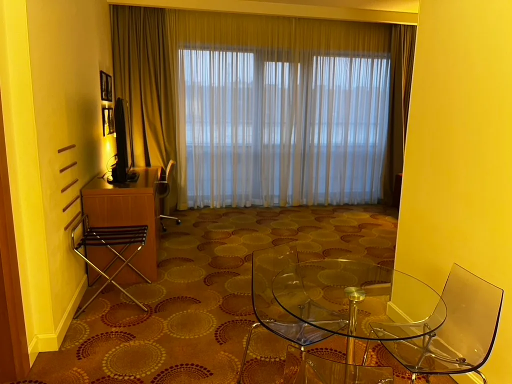 Hotelzimmer mit Couchtisch und Stühlen im Vordergrund