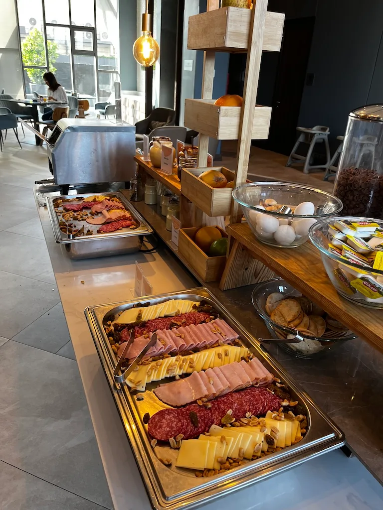 Frühstücksbuffet mit Käse, Schinken und Eiern auf Holzregal