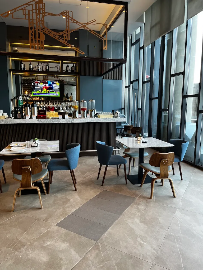 Lounge mit Sesseln und Tischen in Grautönen