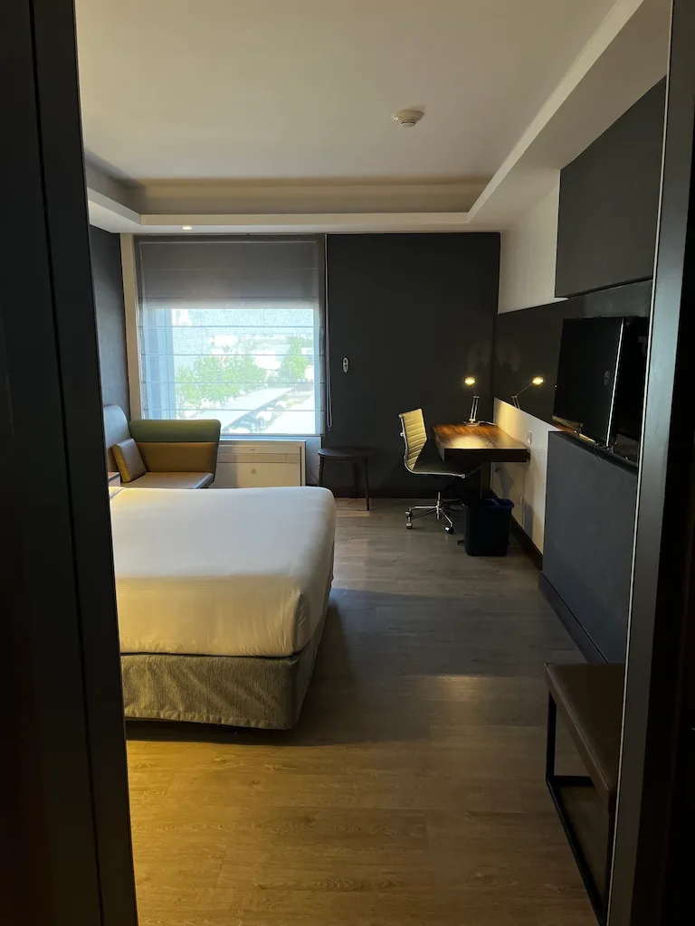 Hotelzimmer mit Doppelbett und Schreibtisch in Grautönen
