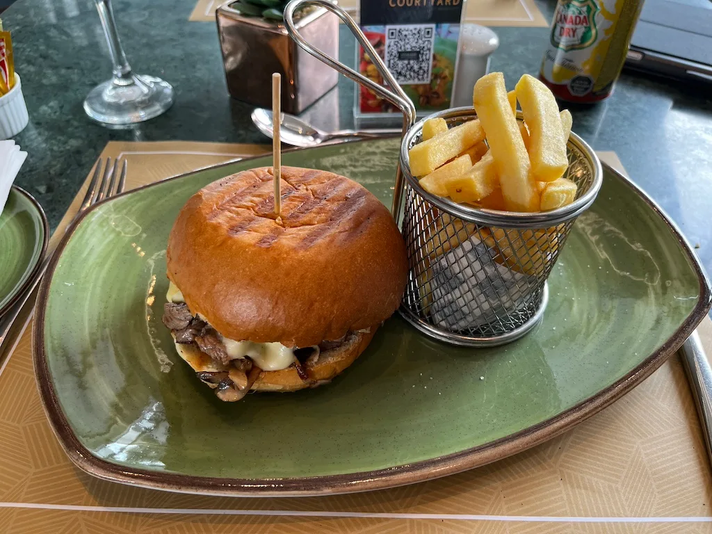 Hamburger mit Pommes frites auf grünem Teller