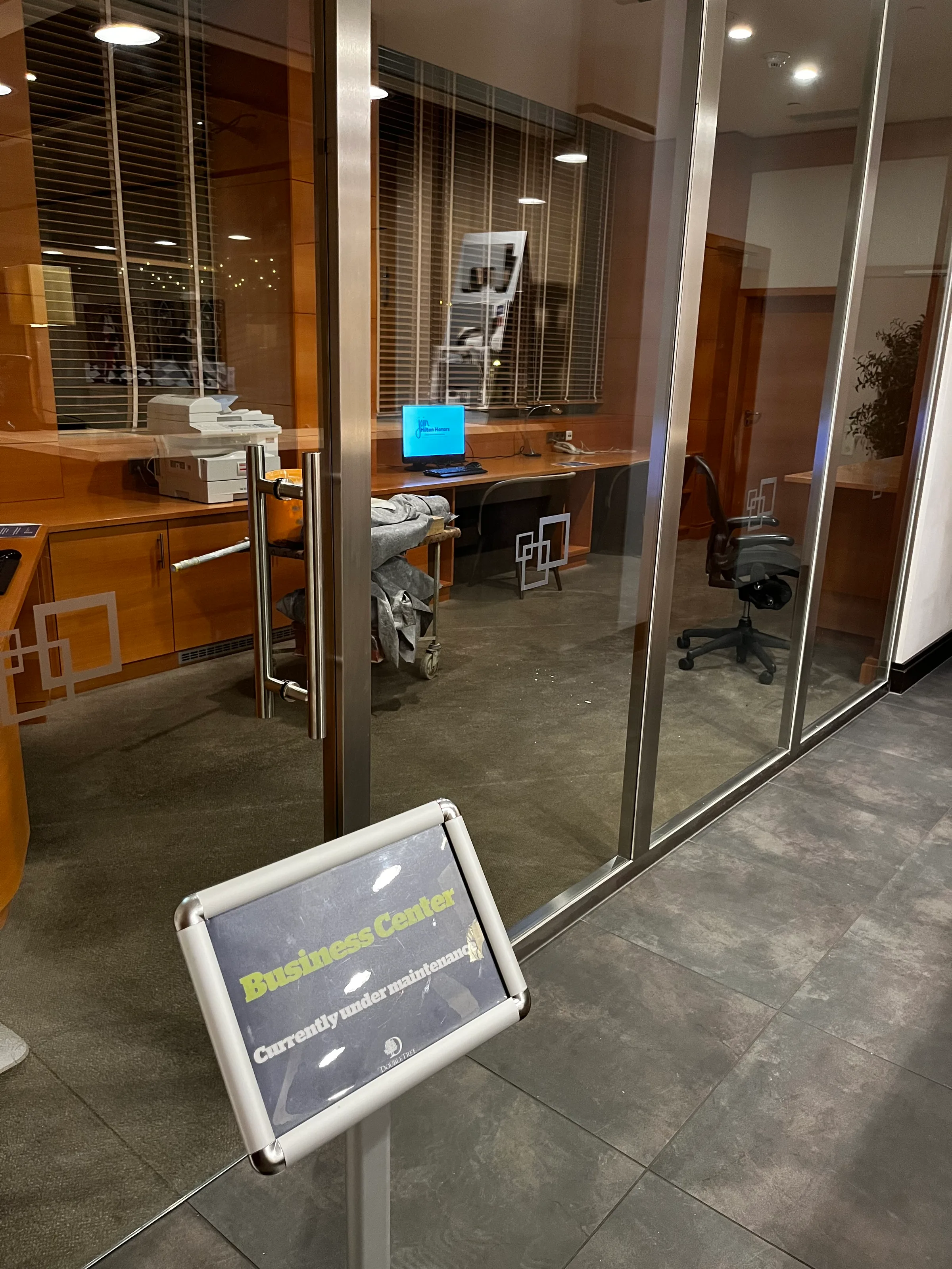 Business Center mit Schreibtisch und Computer unter Wartungsschild