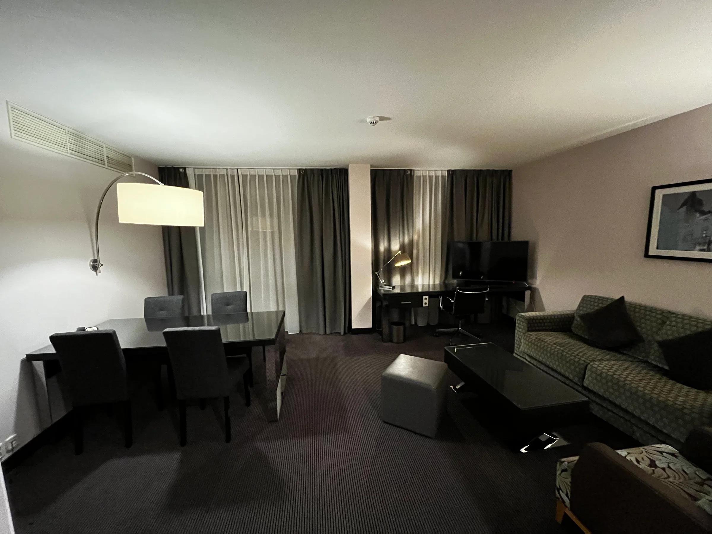 Hotelzimmer mit Essbereich und Couch in neutralen Farben