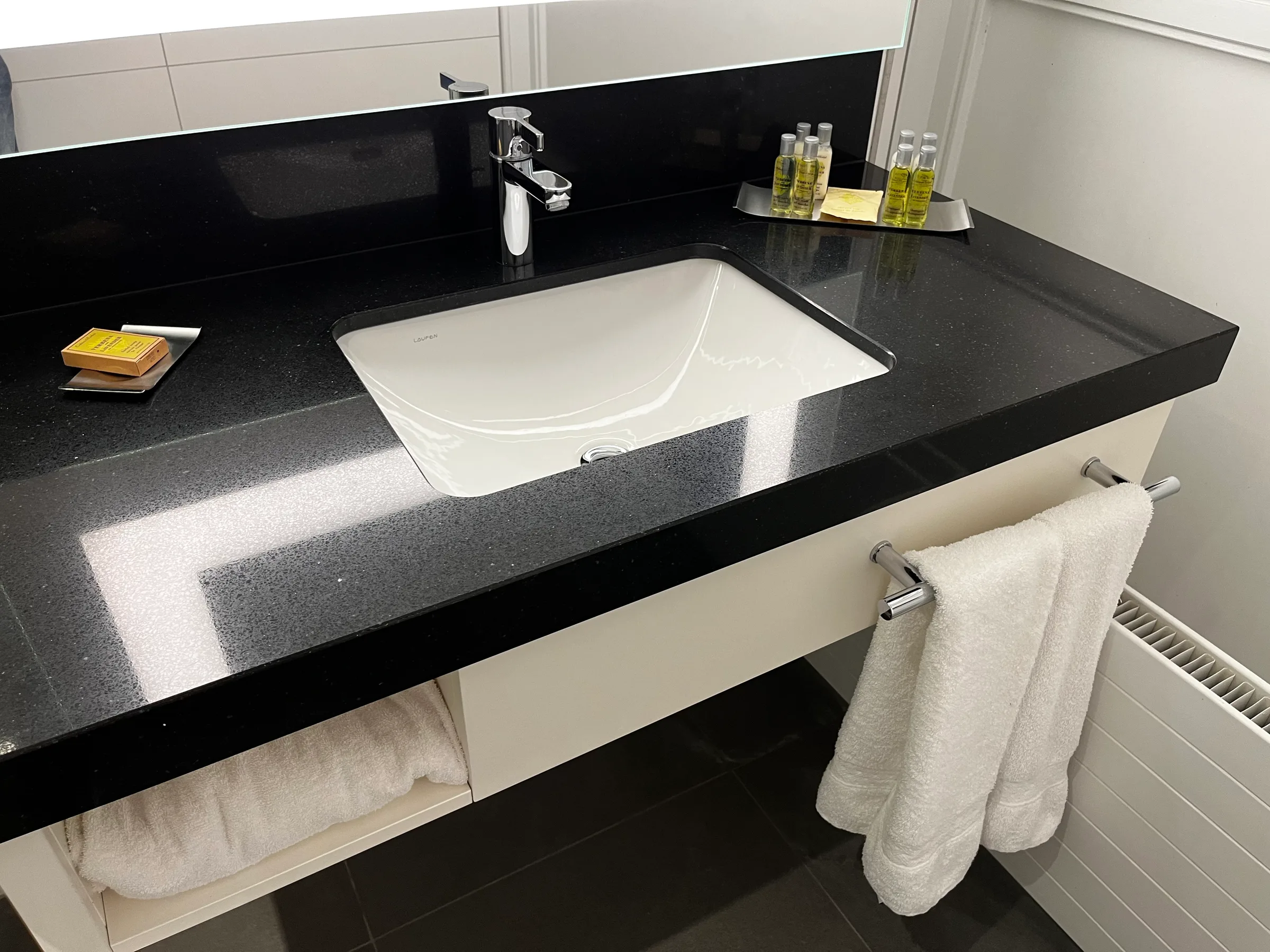 Schwarze Arbeitsplatte mit eingebautem Waschbecken und Handtüchern