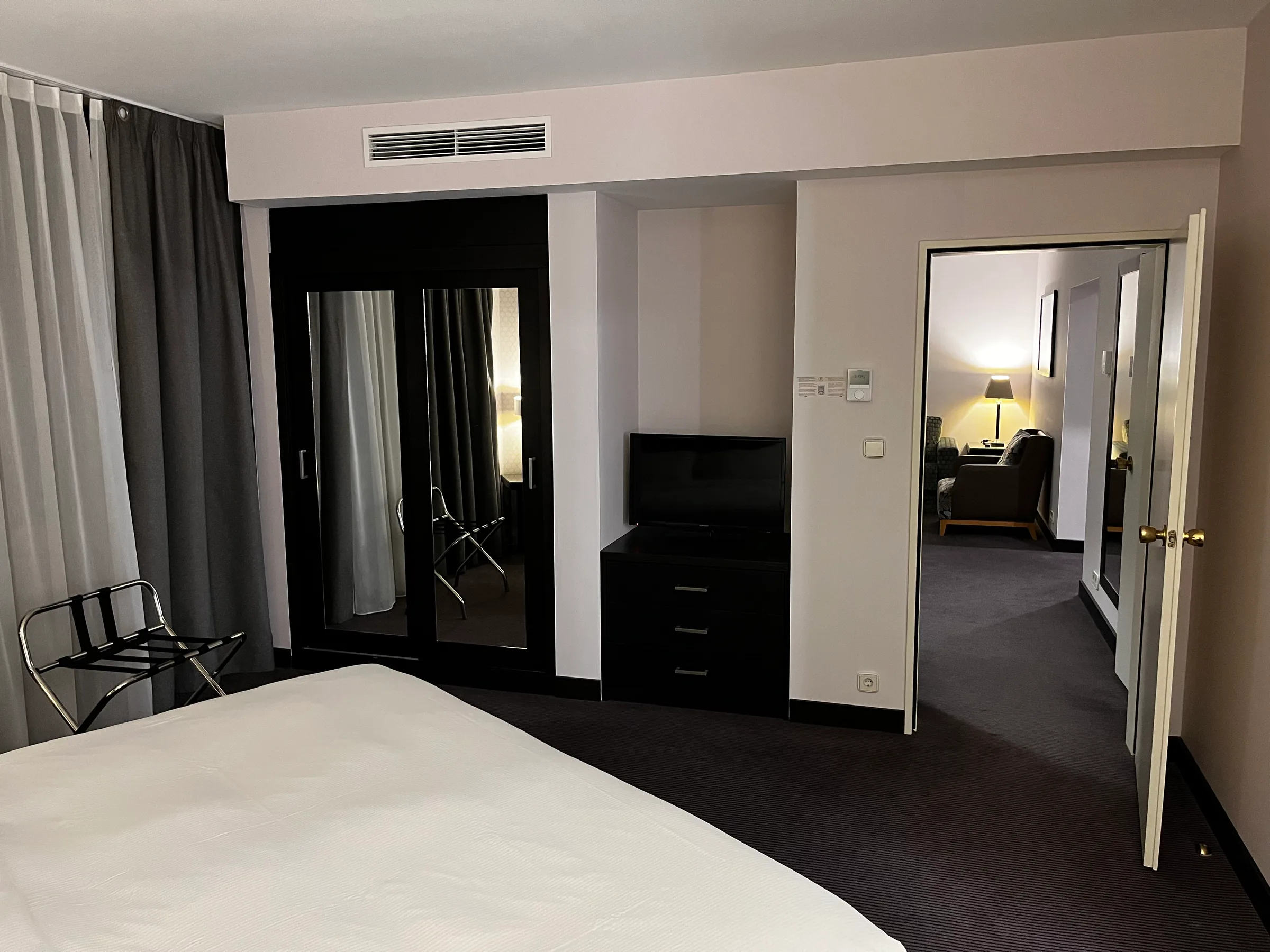 Hotelzimmer mit Doppelbett und Schrank in Grautönen