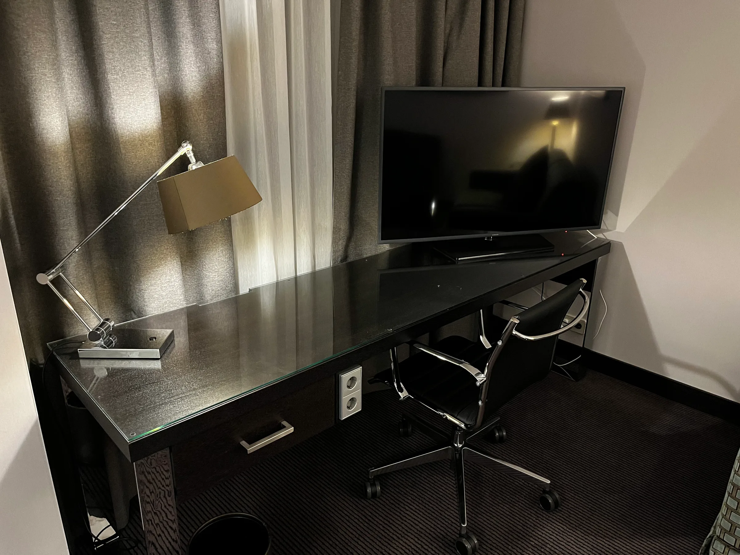Hotelzimmer mit Schreibtisch, Stuhl und Fernseher