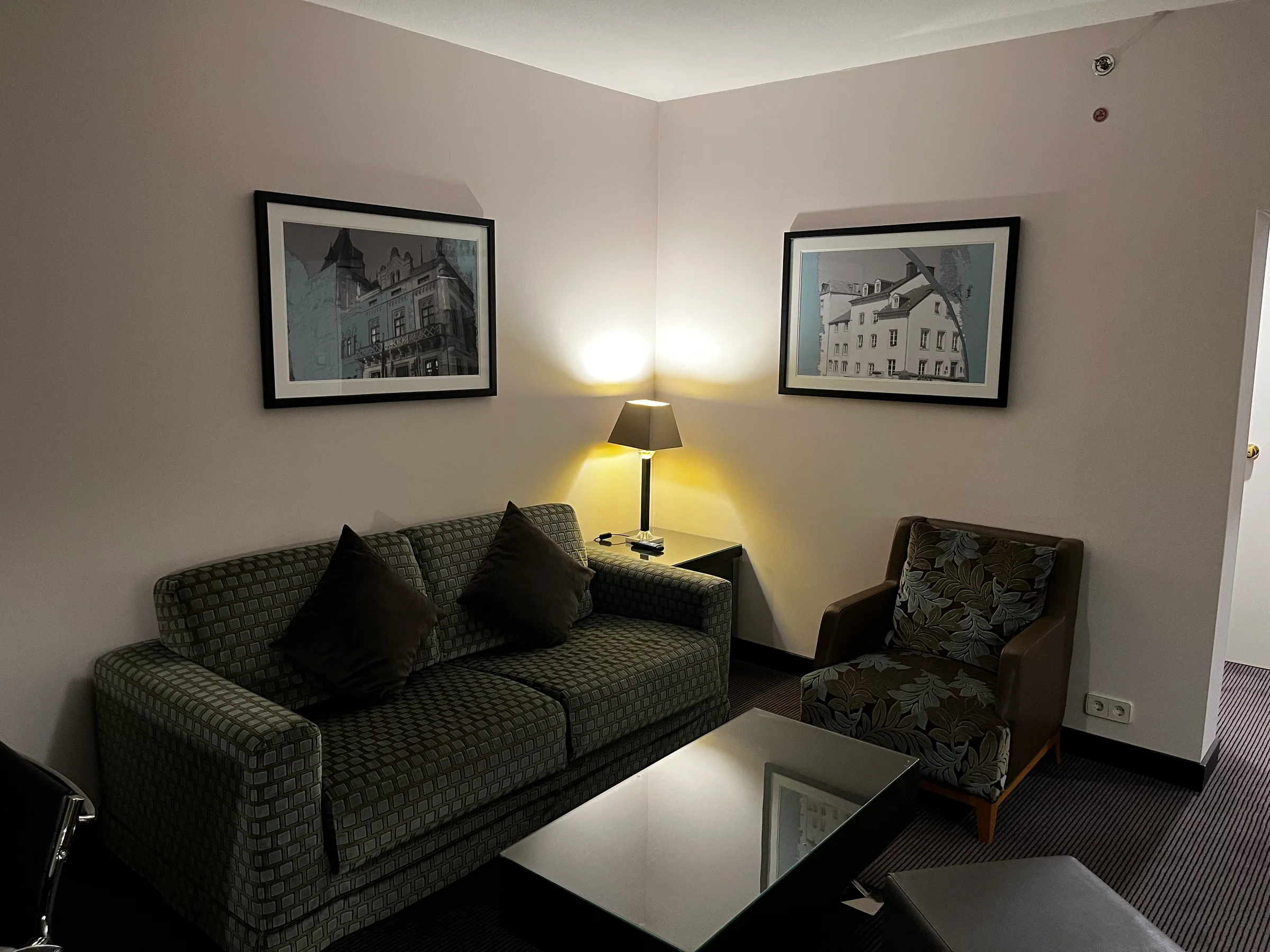 Hotelzimmer mit Couch und Sessel in gedämpftem Licht