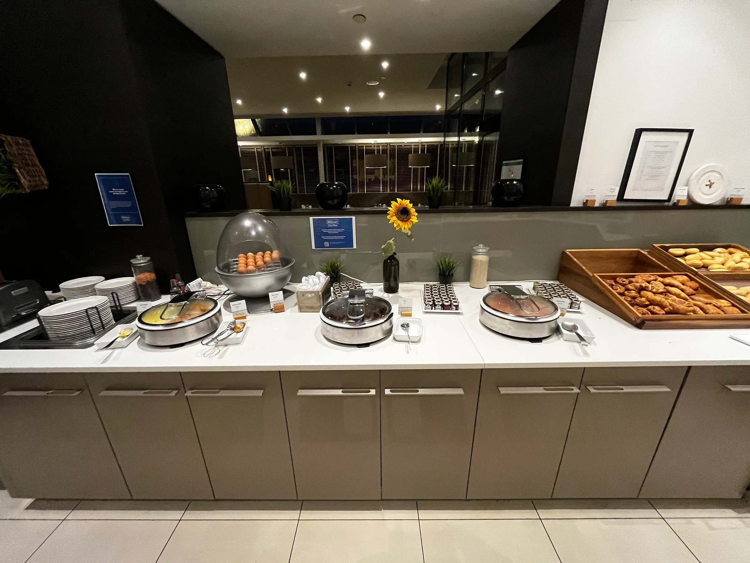 Frühstücksbuffet mit verschiedenen Speisen und Gebäck auf einem langen Tisch