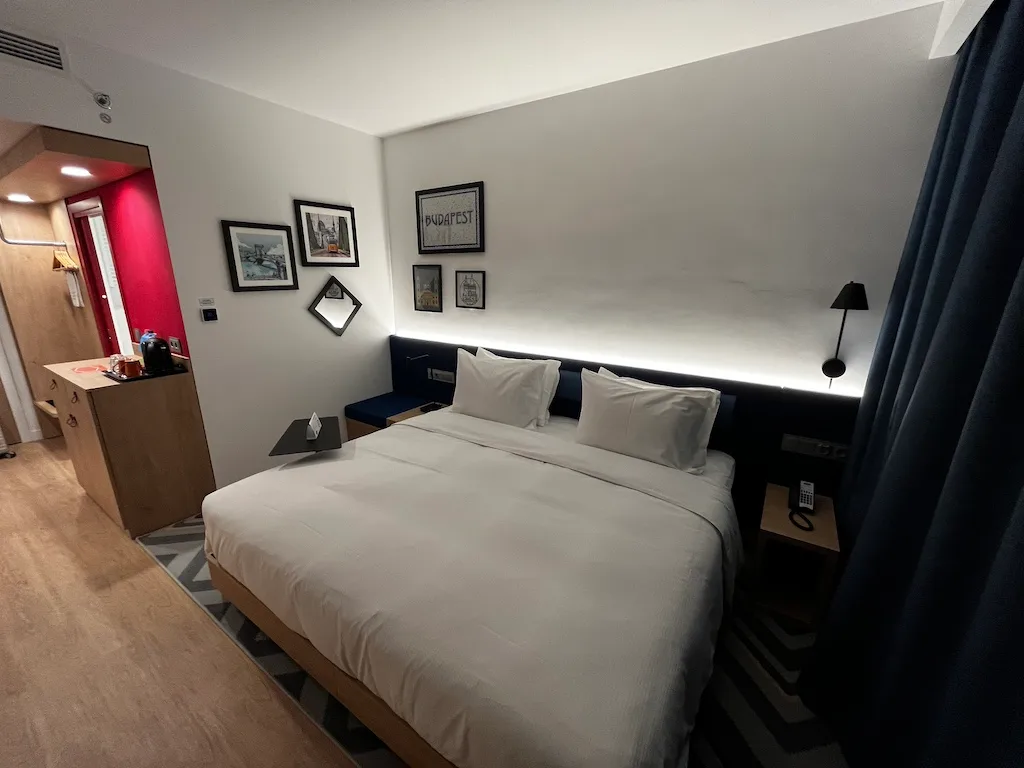Hotelzimmer mit Doppelbett und Wandbildern