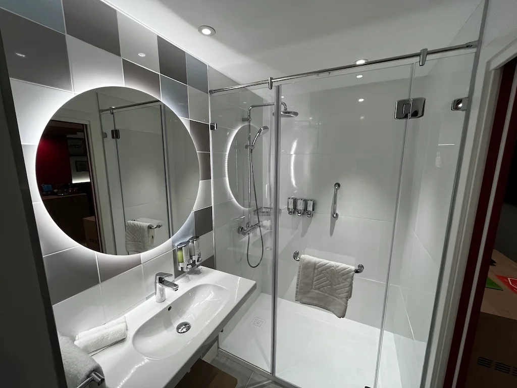 Moderne Dusche mit Glastür im Hotelbad