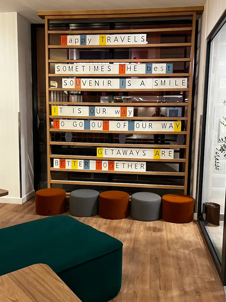 Hotellobby mit Sitzgelegenheiten und Spruchwand