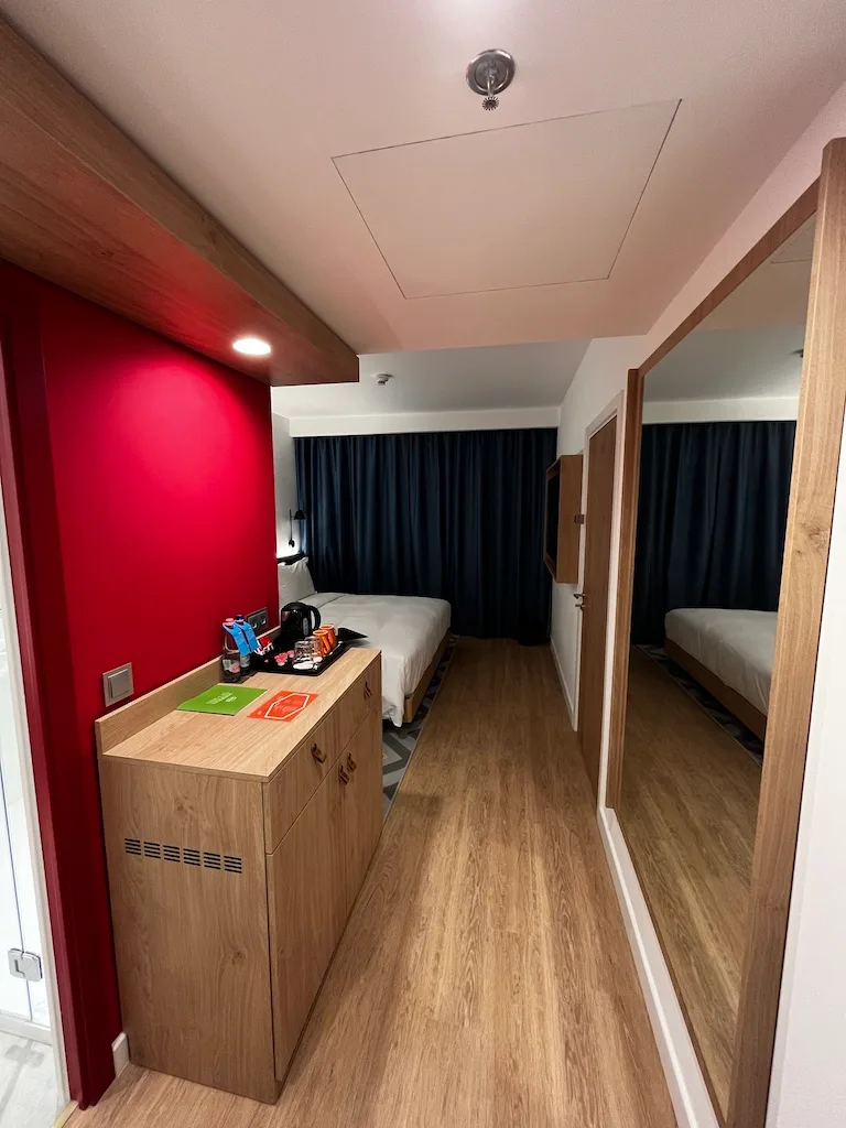 Hotelzimmer mit Doppelbett und rotem Akzentwand