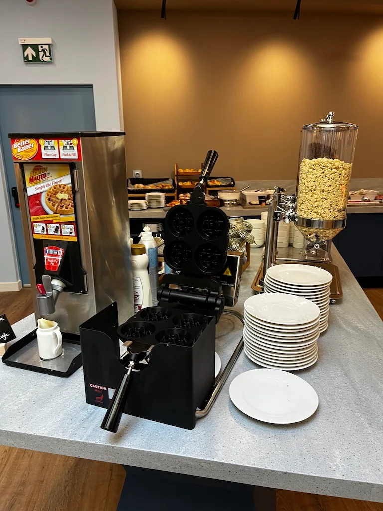 Frühstücksbuffet mit Waffeleisen und Kaffeezubereitung