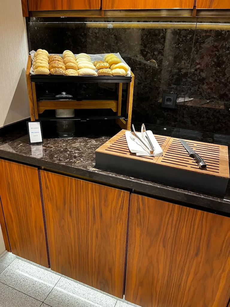 Frühstückstisch mit Brot und Servietten auf Holzplatte