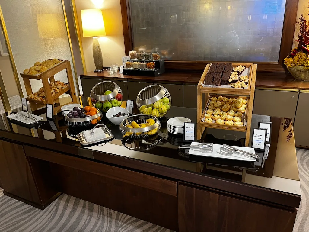 Frühstückbuffet mit Obst, Kuchen und Gebäck auf Holzregalen