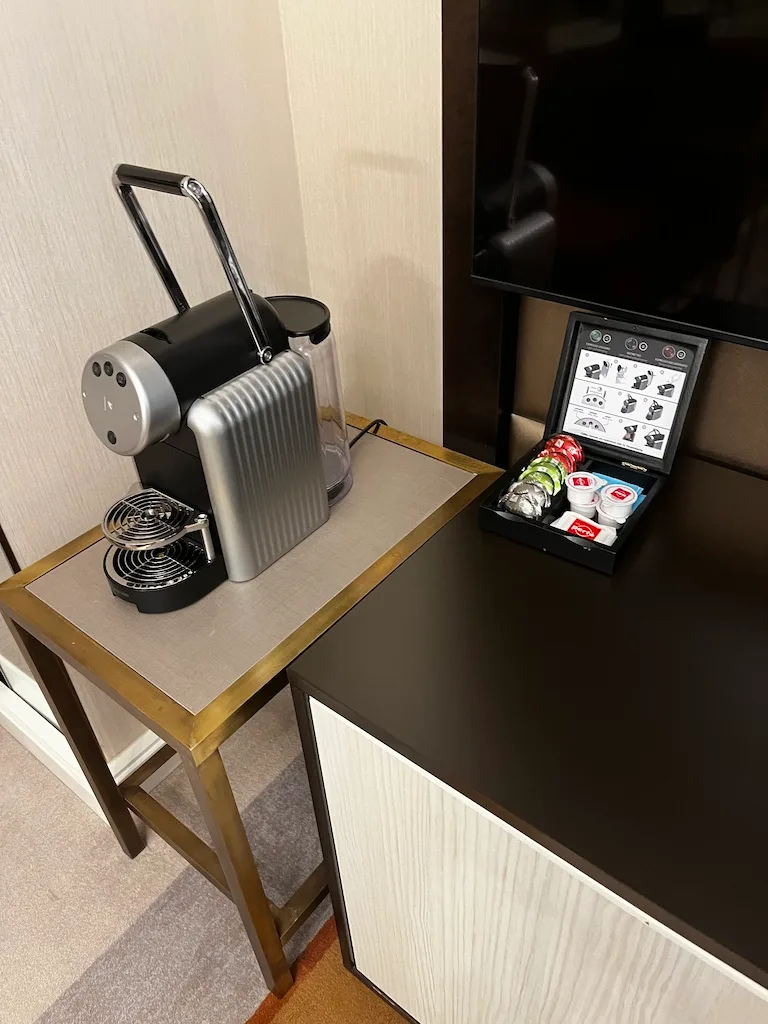 Kaffeevollautomat auf Tisch neben Fernseher