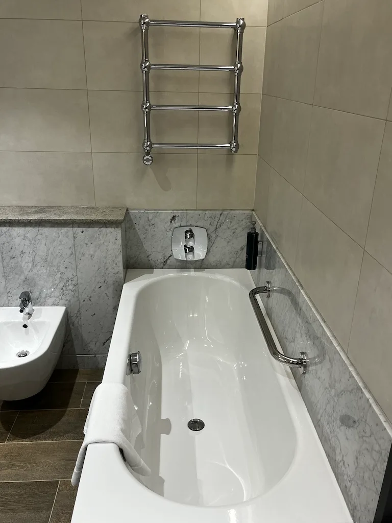 Hotelbad mit Badewanne und Handtuchhalter