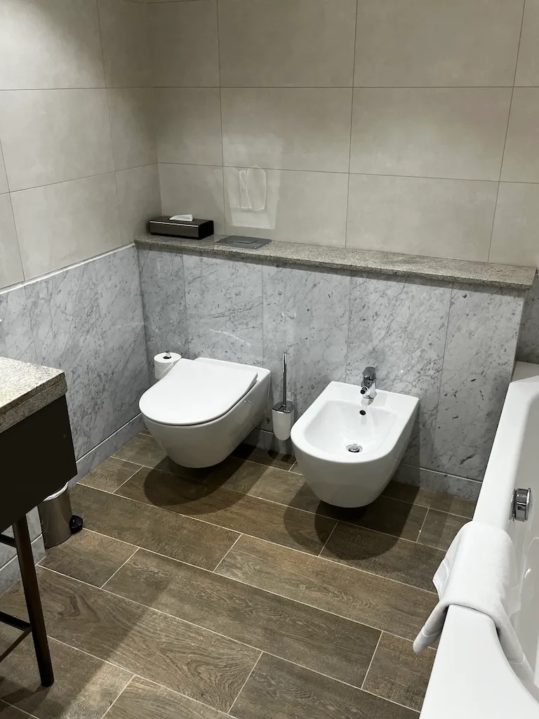 Moderne Toilette mit Bidet und WC in grau-weißem Marmor