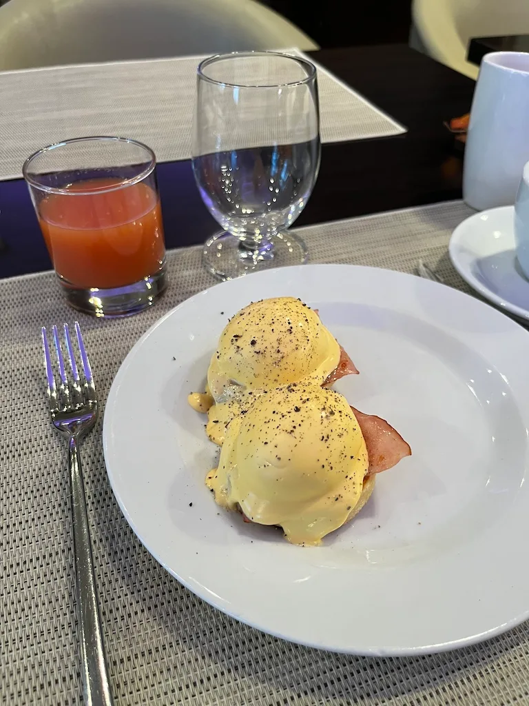 Eierkuchen mit Speck und Sauce Hollandaise auf Teller